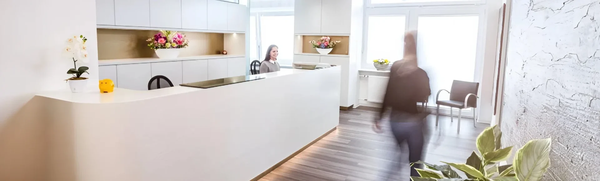 Patient trainiert mit einem Theraband während einer Behandlung mit einer Physiotherapeutin in der Praxis